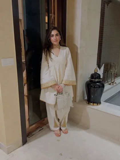 A self-designed off-white peplum kurta with matching pants. The gold trim adds just the right amount of festive touch.