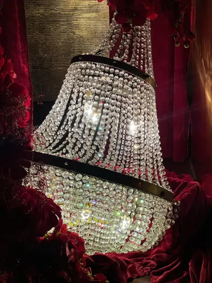 The decor featured opulent details like crystal chandeliers draped in red velvet, cascading floral arrangements, and candelabras that added to the romantic, high-end feel of the celebration.