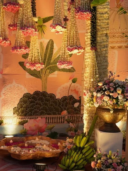 A beautiful corner of the venue, where hanging floral chandeliers and traditional banana plants frame a Pichwai-inspired backdrop. The design is a harmonious blend of art, nature, and tradition.