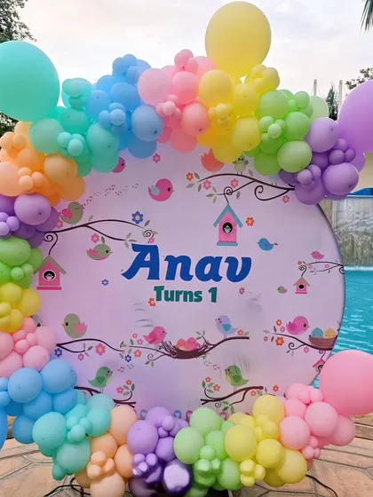 A detail of the bird-themed backdrop and colorful balloon garland.