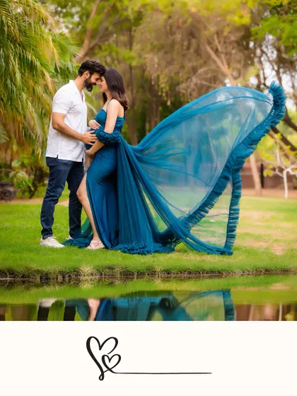 An intimate moment by the water as a couple touches foreheads. The dramatic sweep of the blue gown's train is reflected in the water, adding an artistic touch to this outdoor shot.