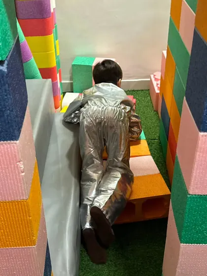 An astronaut exploring a new planet made of colorful foam blocks. The play zone becomes a new world depending on the costume.