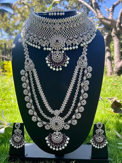 A modern and elegant reception set with a silver finish and dark purple stones. This rental includes a choker, a four-layer long necklace, and matching earrings.