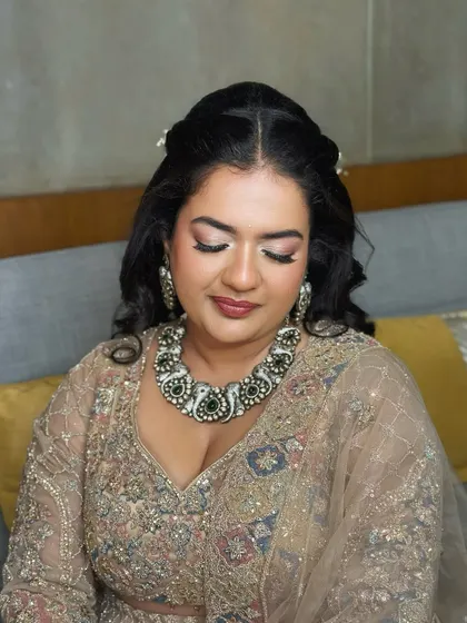 A close-up of the reception makeup. The soft, shimmering eye makeup and neutral lip create a look of timeless elegance that complements her heavy jewellery.