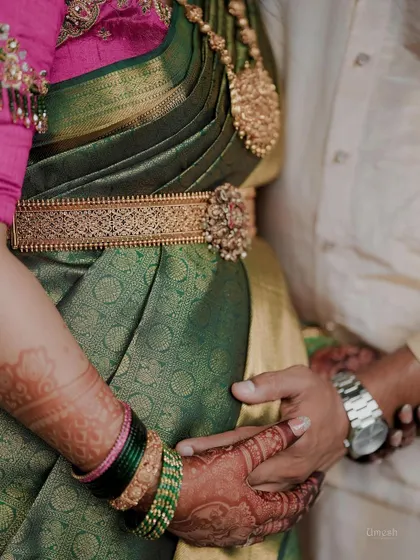 A close-up shot from a Seemantham, focusing on the beautiful silver-based oddiyanam (waist belt) and the intricate henna design.