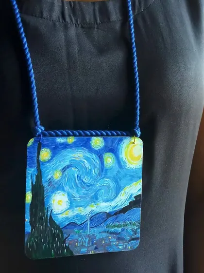 My wearable tribute to a master. This is a miniature hand-painted replica of Van Gogh's 'Starry Night' on a wooden pendant, perfect for art lovers who want to carry a masterpiece with them.