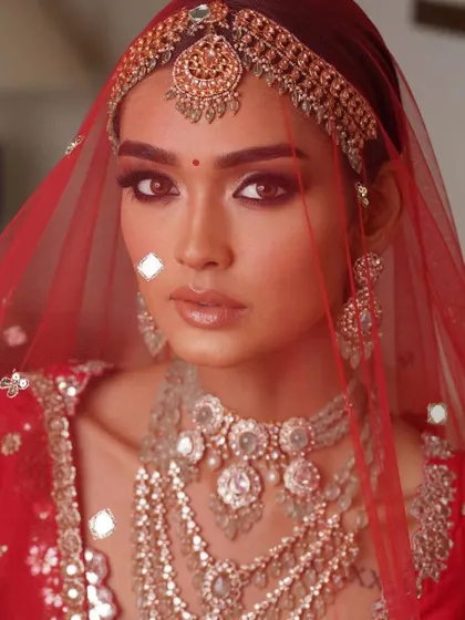 A classic red bridal look with a sheer veil. I teach how to create makeup that looks beautiful both with and without a veil, ensuring the bride is picture-perfect from every angle.
