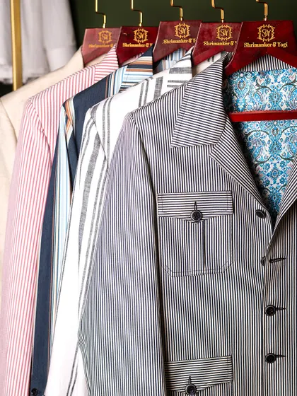 A glimpse into the quiet confidence of bespoke. This rack of striped and patterned jackets, with their unique pocket details and linings, reflects our commitment to superior craftsmanship.
