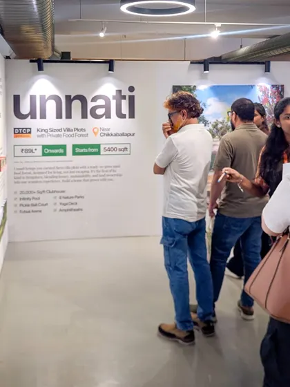A visitor at the Farm Expo looking at the details of our Unnati villa plots.