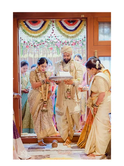 The bride's Griha Pravesh ceremony, a significant moment. Her custom-designed saree and blouse feature intricate gold work, making the moment even more special.
