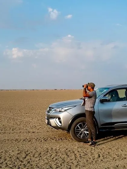 Me using binoculars to scan the horizon at Sambhar Lake. A lot of wildlife photography is about patience, observation, and waiting for the right moment.