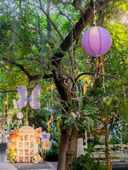 A personalized photo display for a first birthday party. The butterfly and floral theme is carried through in the decor, creating a sweet and memorable corner to showcase precious memories.