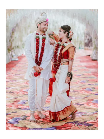 A playful and happy portrait of the couple standing on a vibrant floral carpet, their joy radiating from the photo.