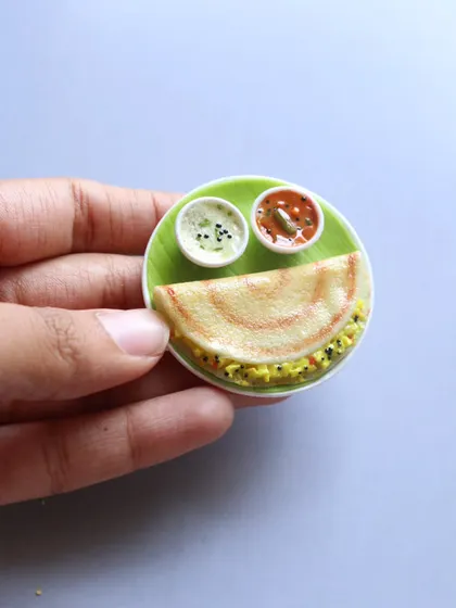 A close-up of a mini masala dosa magnet, showing the crispy texture and the delicious filling.
