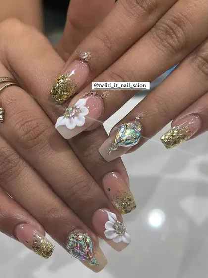 Perfect for wedding shenanigans, this design combines gold glitter, 3D white flowers, and a large, eye-catching crystal on the ring finger. A true statement set for any bride or bridesmaid.