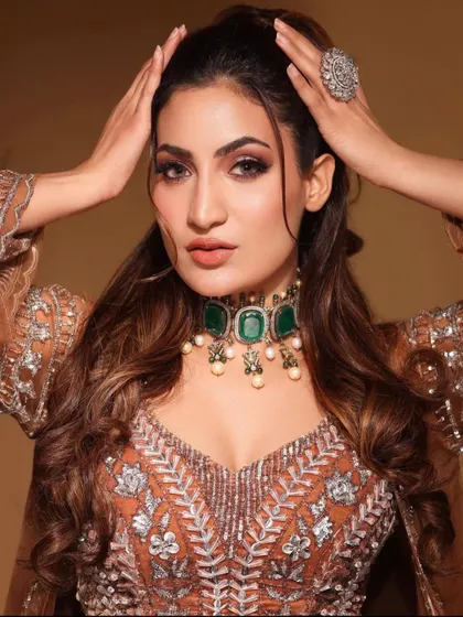 A confident pose by the model, her hands framing her face and showing off the large AD ring.