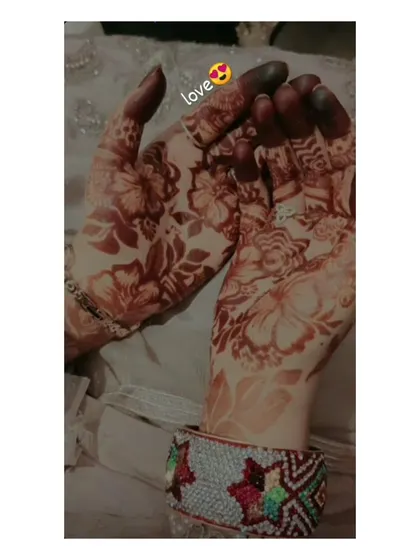 This image captures the warm, reddish-brown tones of a fresh henna stain. The floral pattern looks delicate and beautiful against the skin.