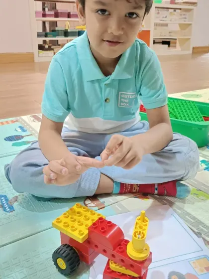 A young student carefully assembling his project. My classes for this age group focus on developing fine motor skills and concentration in a playful, nurturing environment.
