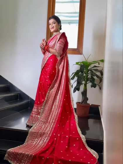 A full-length view of the red bridal saree, showcasing the long, flowing pallu that adds drama and elegance to the bride's walk.