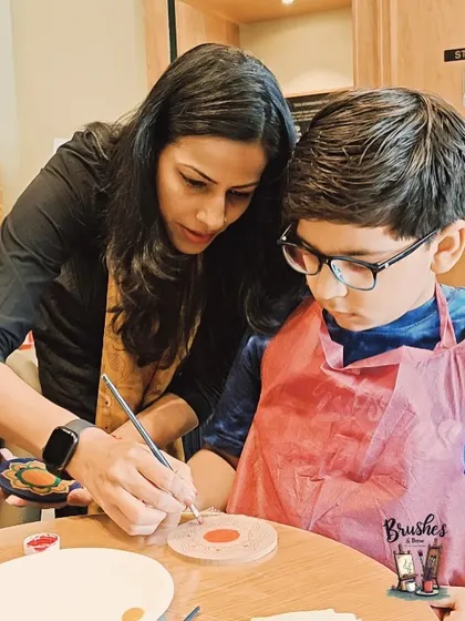 Here I am helping a young student with the details on his wood slice painting. No matter the medium, the goal is always to have fun and learn something new.