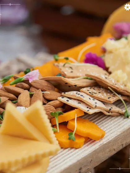 A close up of our grazing board, showing the beautiful textures of artisanal crackers, nuts, and cheeses. Each element is chosen for its quality and how it complements the others.