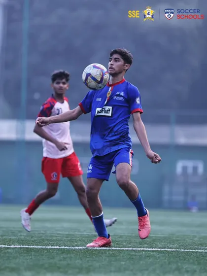 A U17 player demonstrates excellent ball control, chesting the ball down under pressure. We focus on developing technical skills that stand up in competitive matches.