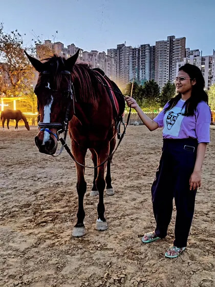 A visitor spends time with one of our friendly horses at dusk. We encourage guests to bond with the animals before or after their ride.