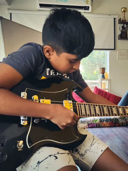 A young guitarist rocking out during our summer camp. We let kids explore different instruments and find the one that speaks to them.