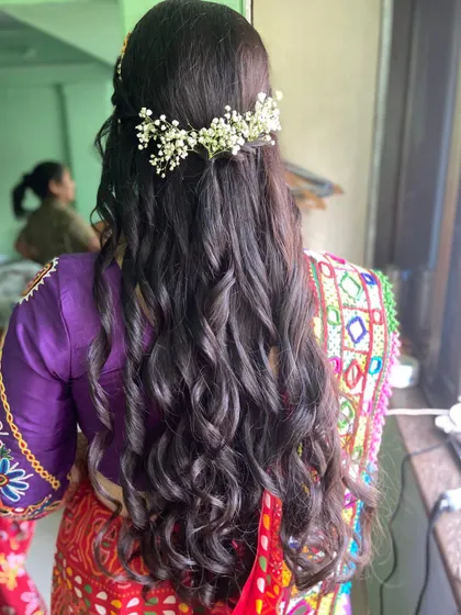 A half-up hairstyle with soft waves, adorned with a crown of baby's breath. A romantic and popular choice for pre-wedding events.