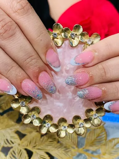 A classic glitter French manicure with a silver glitter gradient on the tips for a sparkling finish.