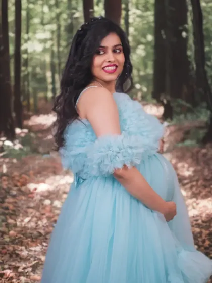 Taking the light blue ruffled gown outdoors for a shoot in a wooded area. The dress's color provides a lovely contrast with the natural tones of the forest.