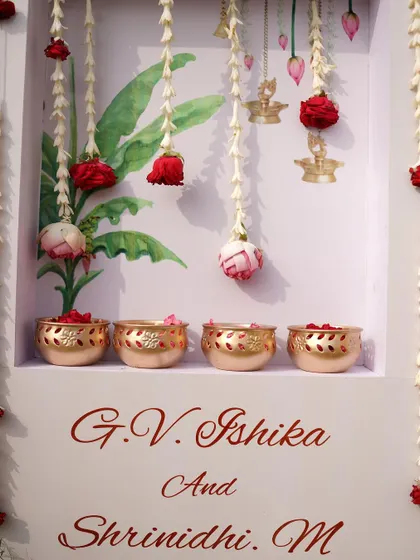 A close-up of a personalized decor piece, featuring the couple's names and delicate hanging floral elements. These small custom details make your wedding truly your own.