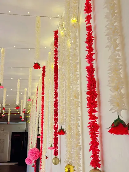 A simple yet stunning ceiling treatment using strings of red and white flowers interspersed with fairy lights. This creates a magical, starry-night effect that is perfect for any celebration.
