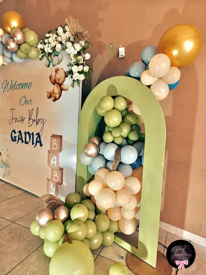 A close-up of the green arch prop filled with balloons, a unique element in the 'Welcome Baby Boy' decor.