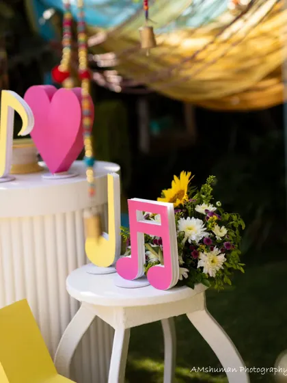 A close-up of the music-themed decor, with bright pink musical note cutouts and a fresh floral arrangement, showcasing the playful and colorful vibe of the event.