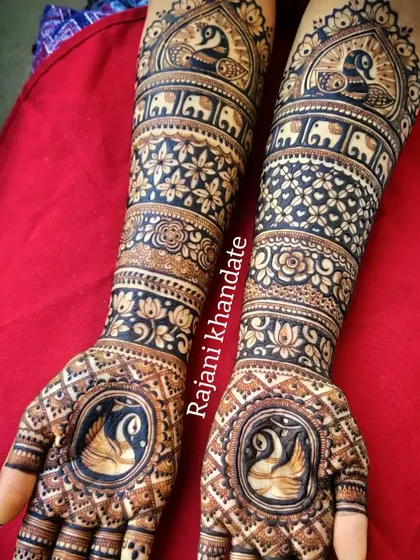 A beautiful bridal design featuring swans in a central frame on each palm. The arms are adorned with bands of elephants, peacocks, and floral patterns, creating a design rich in symbolic motifs.