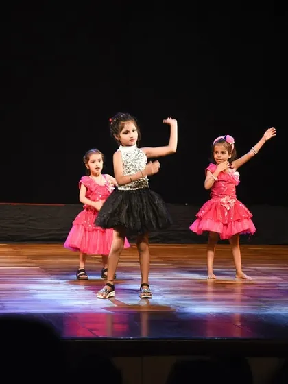 A close-up of the girls' coordinated arm movements and happy expressions during their routine.