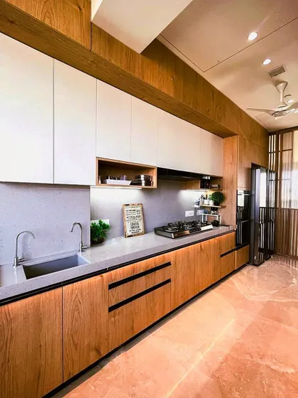 A beautiful kitchen that blends natural wood tones with clean white cabinets. The open shelving and under-cabinet lighting create a warm and functional workspace.