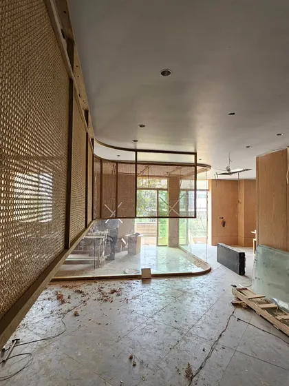 A curved wall partition featuring woven rattan panels is taking shape. This work-in-progress shot highlights our use of natural, sustainable materials to add warmth and texture to an interior space.