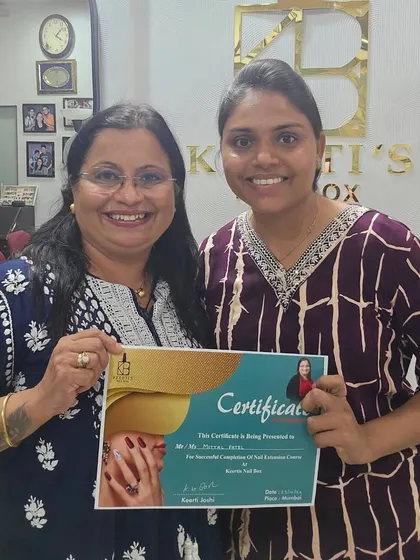 Mittal proudly holding her certificate after completing the Nail Extension Course. She is now equipped with the skills to build her own business.