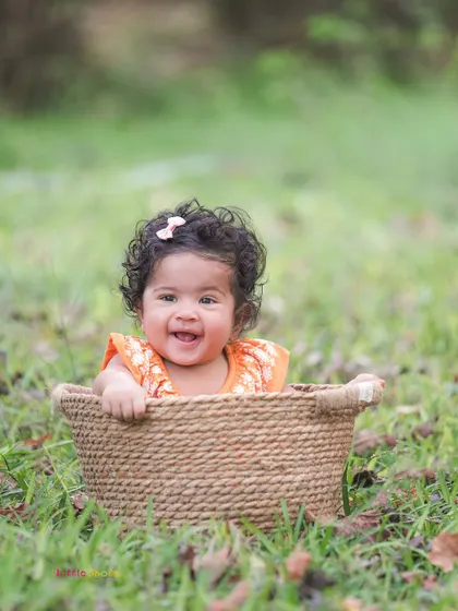 A basket of joy! This baby's radiant smile, captured during an outdoor session, shows the simple happiness of being in nature.
