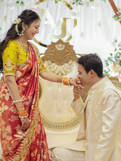A classic, chivalrous moment with the groom kissing the bride's hand during their engagement.