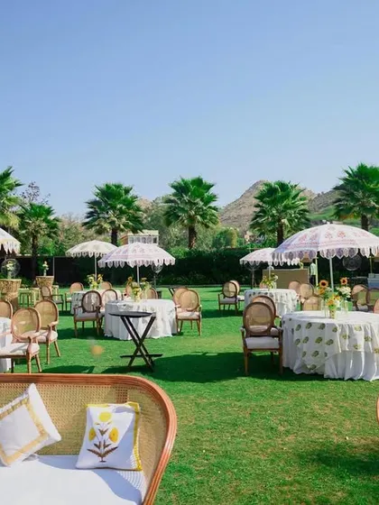 The full seating area for the haldi, with custom umbrellas and cane furniture creating a cohesive and stylish look.
