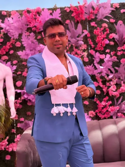 Holding the mic, ready to engage the crowd. The blue suit is a versatile choice that works for both formal and fun events.