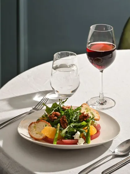 A closer look at my pear and walnut salad, served with a glass of red wine. A classic pairing for a sophisticated lunch.