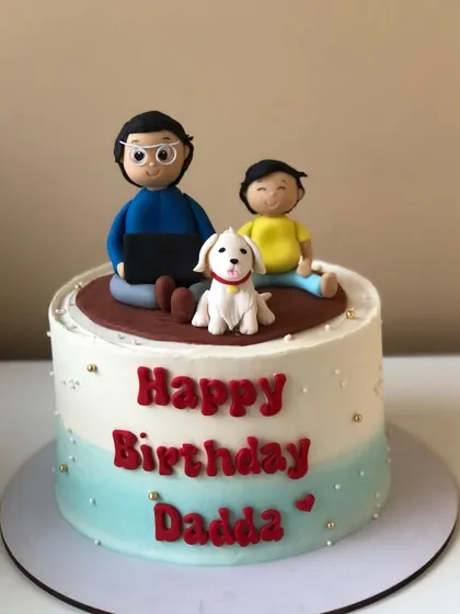 A heartwarming cake for "Dadda," featuring handcrafted figures of him, his child, and their beloved dog.