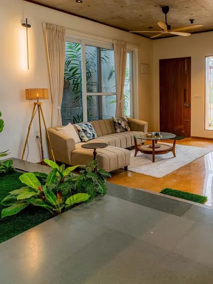 The living room of 'The Valley', a small house design featuring a sunken indoor garden. This biophilic element acts as the natural centerpiece of the home, promoting a sense of calm and connection to nature.