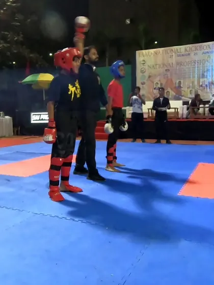 The referee raises our young champion's hand in victory after a dominant performance in the point fighting category.