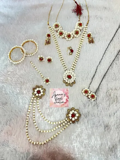 This halwa jewellery set is accented with red details and gold charms, offering a more ornate and traditional look for a new bride.