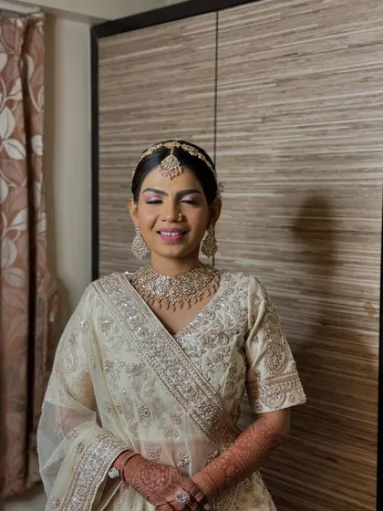 A beautiful portrait of Maya, with her eyes closed, showcasing the soft pink eyeshadow and flawless base of her elegant wedding makeup.